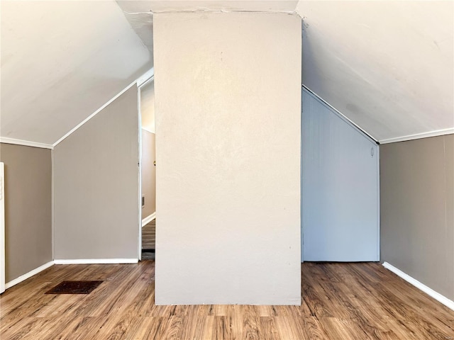 bonus room with lofted ceiling, wood finished floors, and baseboards