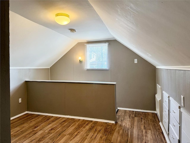 bonus room featuring baseboards, lofted ceiling, and wood finished floors