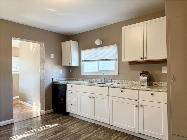 kitchen featuring dark wood finished floors, white cabinets, plenty of natural light, and a sink