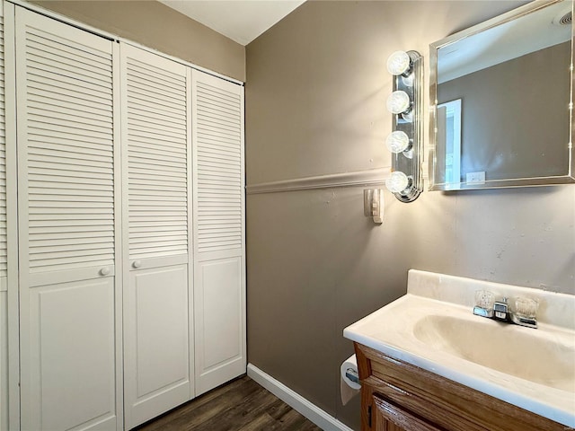 bathroom featuring vanity, wood finished floors, a closet, and baseboards