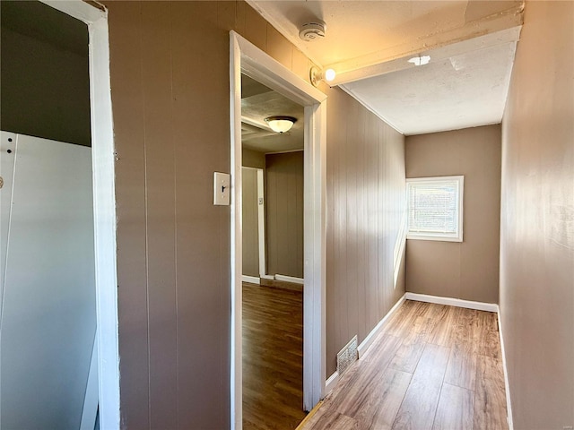 hallway featuring baseboards and light wood-type flooring