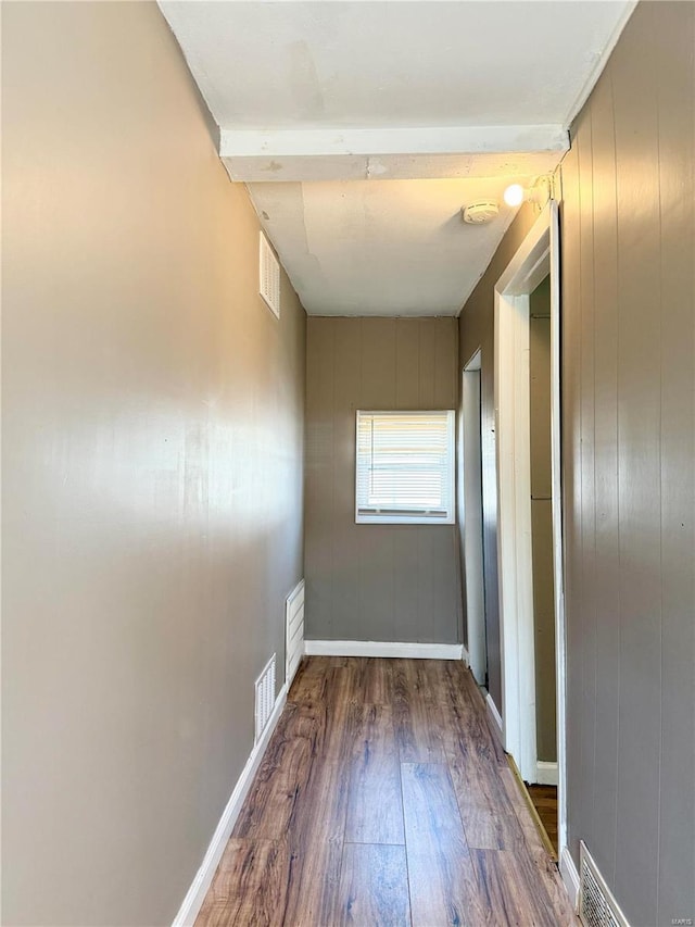 hall featuring dark wood finished floors, baseboards, and visible vents