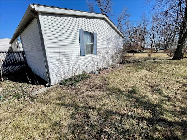 view of side of home with a lawn and a wooden deck