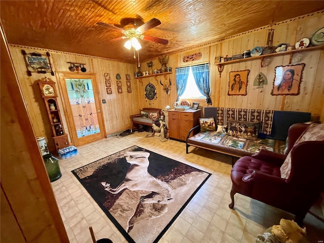 living area featuring tile patterned floors, wood walls, wood ceiling, and a ceiling fan