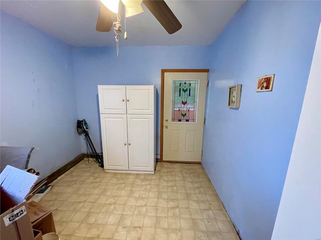 interior space featuring light floors, baseboards, and a ceiling fan