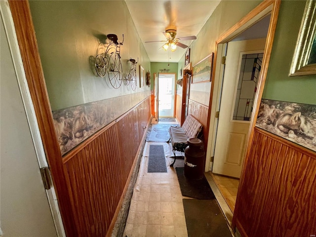 hallway featuring wood walls and wainscoting