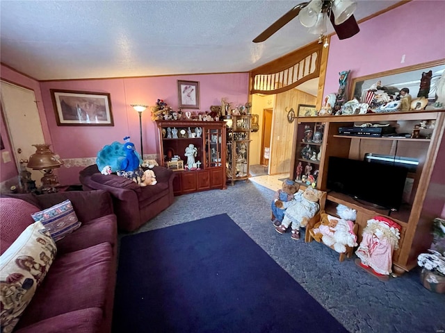 carpeted living room featuring a ceiling fan and a textured ceiling