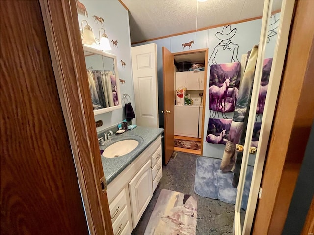 bathroom with stone finish floor, washer / clothes dryer, a textured ceiling, crown molding, and vanity