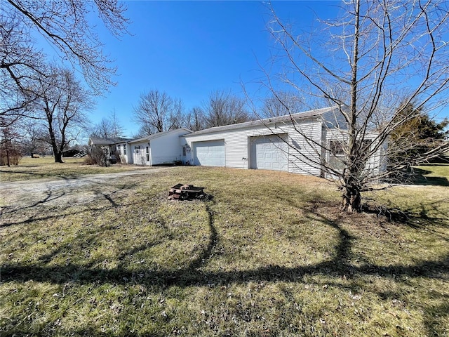 exterior space featuring driveway, an attached garage, and a yard