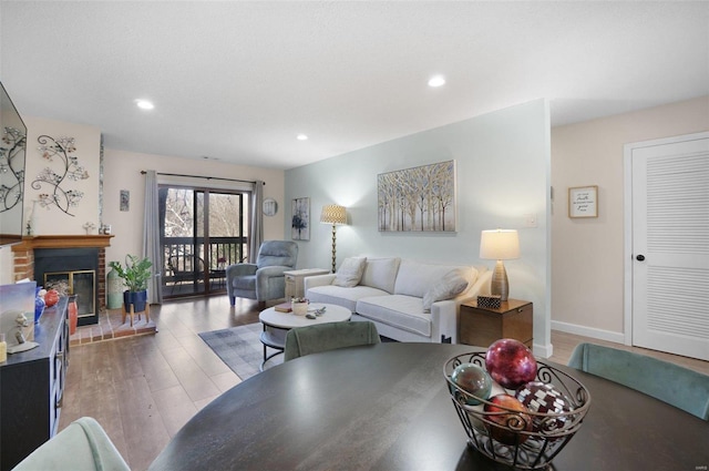 living room with recessed lighting, light wood-type flooring, baseboards, and a fireplace