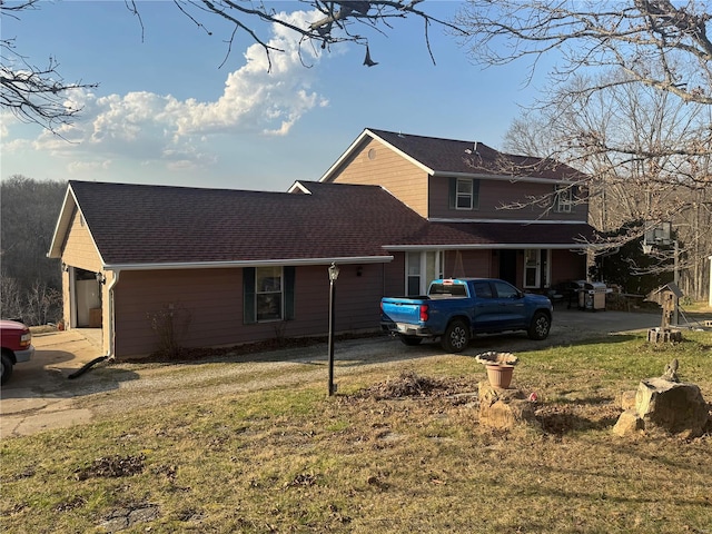 exterior space featuring a lawn and a shingled roof