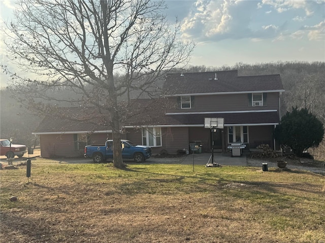 rear view of house featuring a patio and a yard