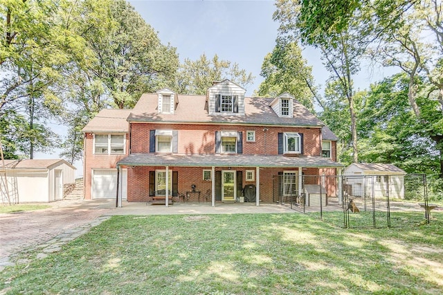 rear view of property featuring an attached garage, a yard, fence, and driveway