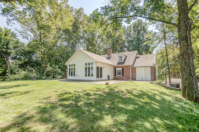 rear view of property featuring brick siding, a patio, a chimney, and a yard