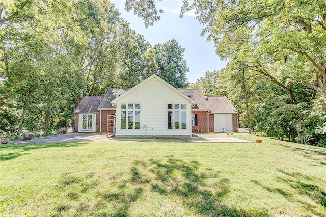 view of front of home featuring brick siding, a front lawn, and a patio area