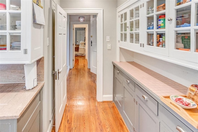 hall with light wood-style flooring and baseboards