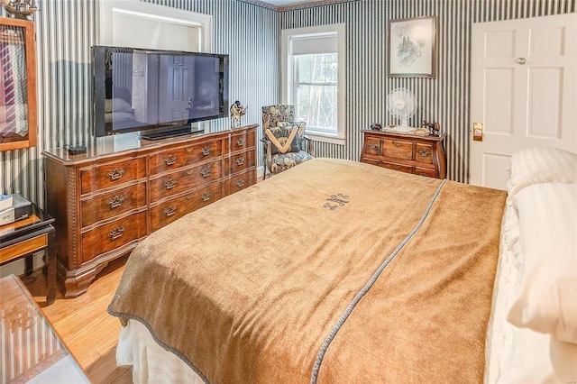 bedroom with wallpapered walls and wood finished floors