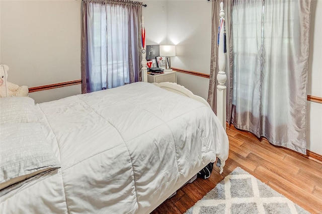 bedroom with wood finished floors and baseboards