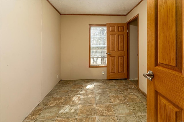 empty room featuring a textured ceiling and crown molding