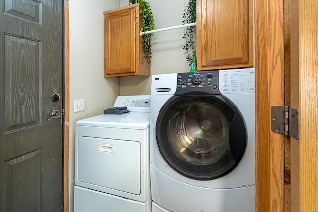 laundry room with washing machine and dryer and cabinet space