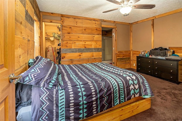 carpeted bedroom featuring a closet, a textured ceiling, ceiling fan, and wooden walls