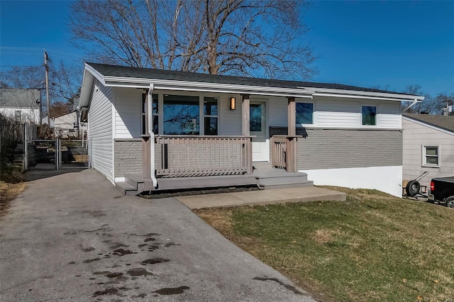 view of front of home featuring a front lawn, a gate, fence, and covered porch