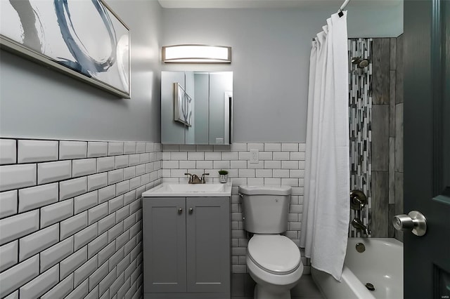 full bath featuring vanity, shower / bath combination with curtain, wainscoting, tile walls, and toilet