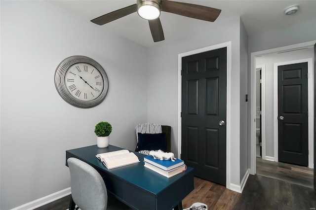 office area with baseboards, dark wood-type flooring, and a ceiling fan