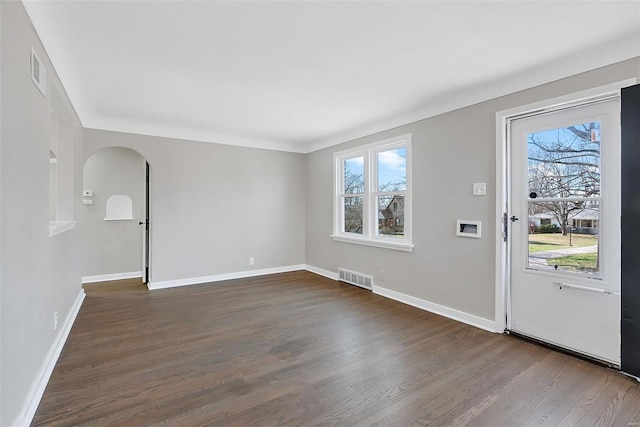 entryway featuring visible vents, arched walkways, dark wood-type flooring, and baseboards