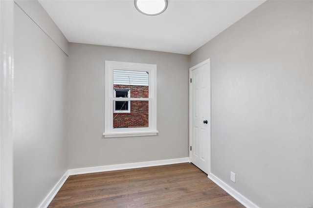 empty room with baseboards and wood finished floors