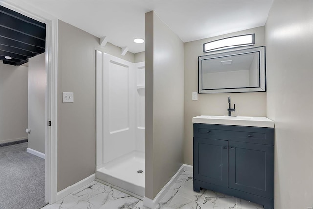 bathroom with marble finish floor, vanity, a shower stall, and baseboards