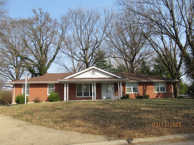 ranch-style home featuring a front lawn and brick siding