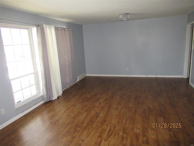 unfurnished room with a wealth of natural light, baseboards, and wood finished floors