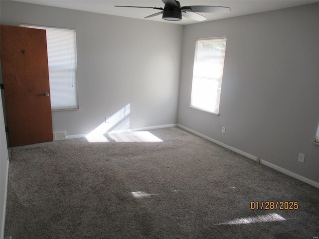 carpeted empty room with baseboards, visible vents, and ceiling fan