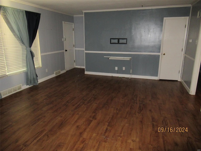 unfurnished room featuring visible vents, baseboards, wood finished floors, and crown molding