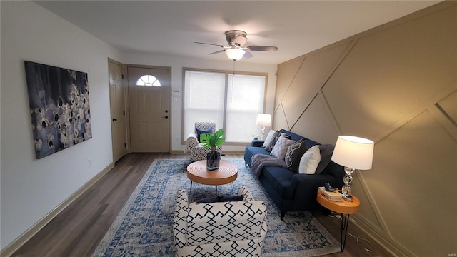 living area featuring baseboards, wood finished floors, and a ceiling fan