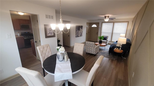 dining room featuring ceiling fan with notable chandelier, wood finished floors, and visible vents