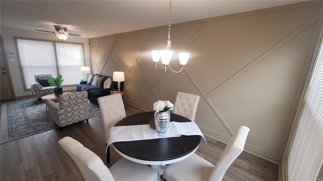 dining area with ceiling fan with notable chandelier, wood finished floors, and baseboards