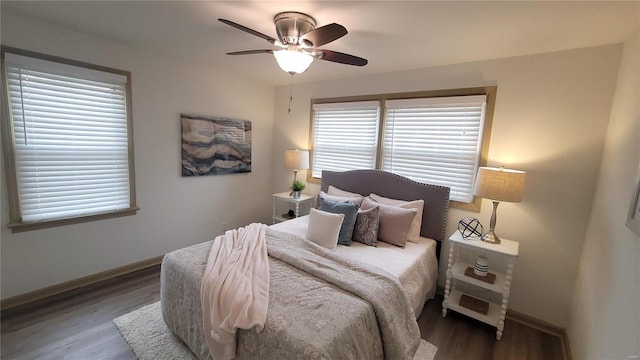 bedroom featuring baseboards, wood finished floors, and a ceiling fan