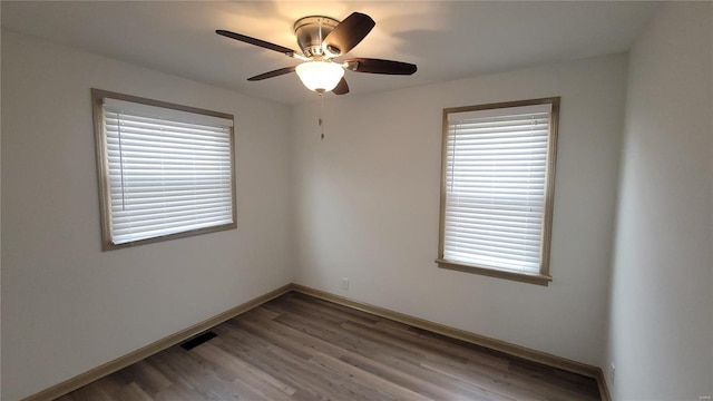 spare room with visible vents, light wood-style floors, a healthy amount of sunlight, and ceiling fan