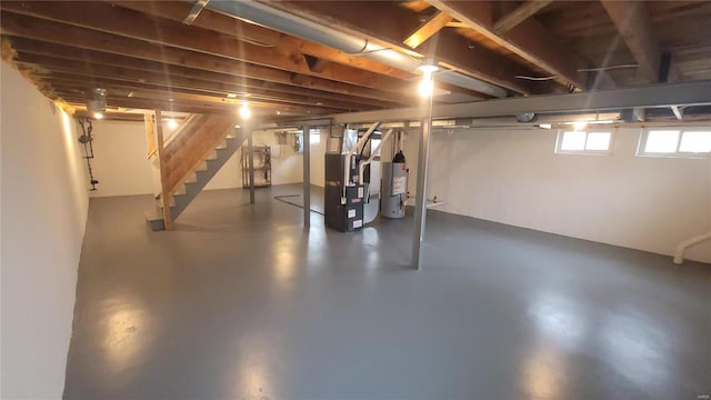 below grade area featuring heating unit, stairway, and gas water heater