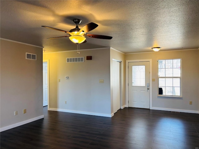 interior space with visible vents, dark wood-type flooring, ornamental molding, and a ceiling fan