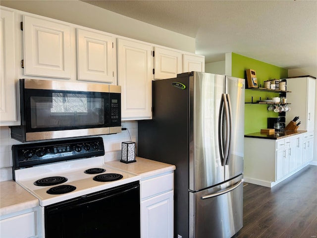 kitchen featuring dark wood-type flooring, backsplash, appliances with stainless steel finishes, and white cabinetry