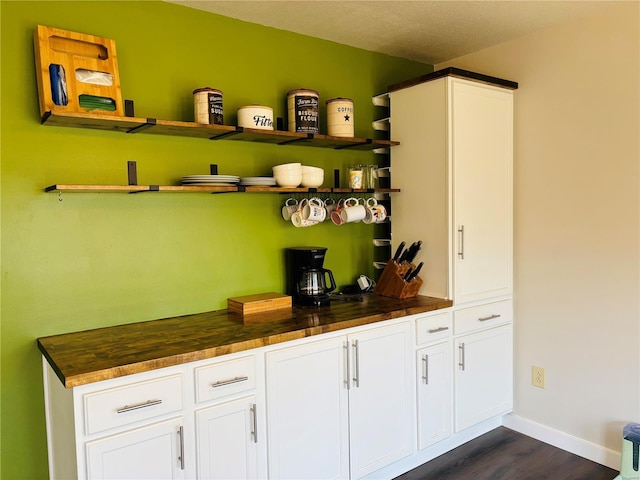 bar featuring dark wood finished floors and baseboards