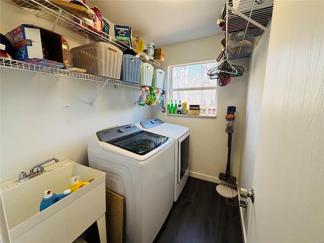 laundry area featuring dark wood-type flooring, baseboards, washer and clothes dryer, laundry area, and a sink