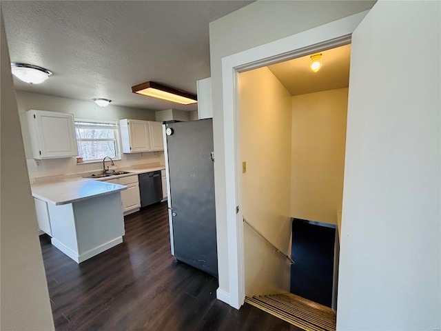 kitchen with white cabinetry, dark wood finished floors, freestanding refrigerator, a sink, and dishwasher