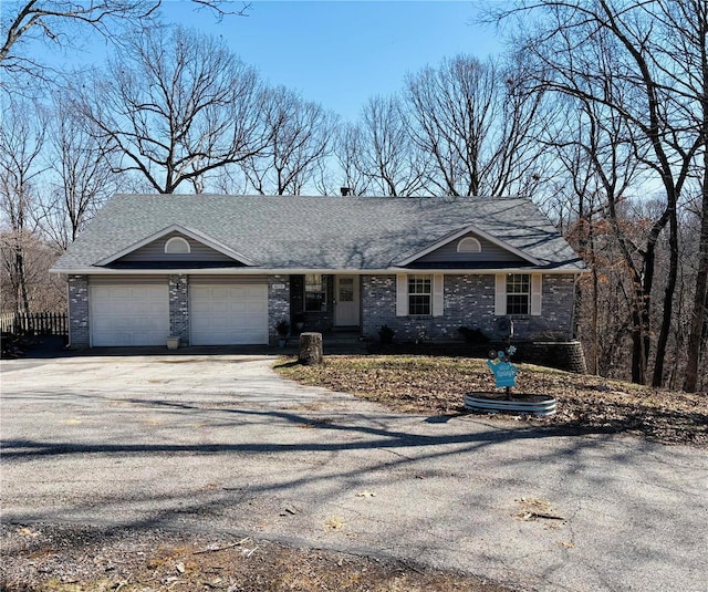 ranch-style house with aphalt driveway, brick siding, and an attached garage