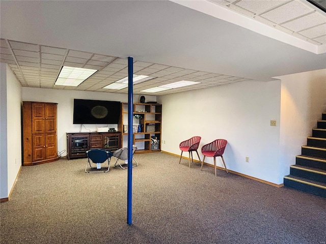 finished basement featuring stairway, a paneled ceiling, baseboards, and carpet floors