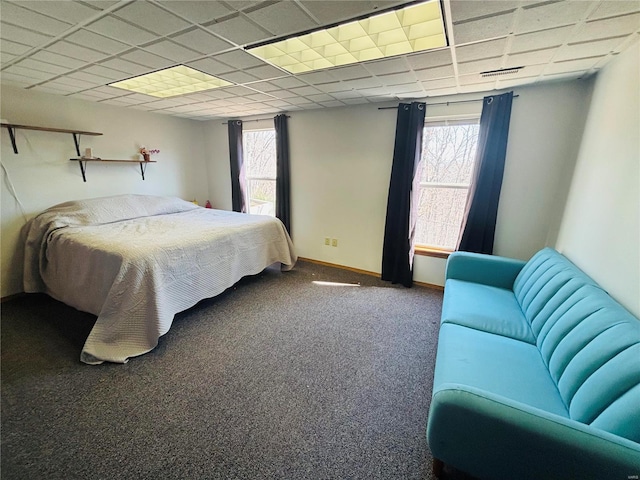 bedroom with multiple windows, baseboards, a paneled ceiling, and carpet