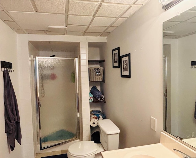 full bathroom featuring a drop ceiling, vanity, toilet, and a shower stall